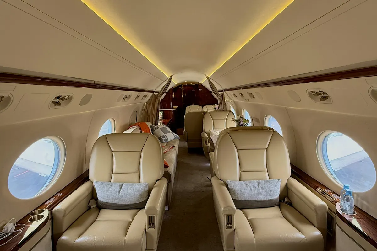 Warmly lit private jet cabin with leather club seats