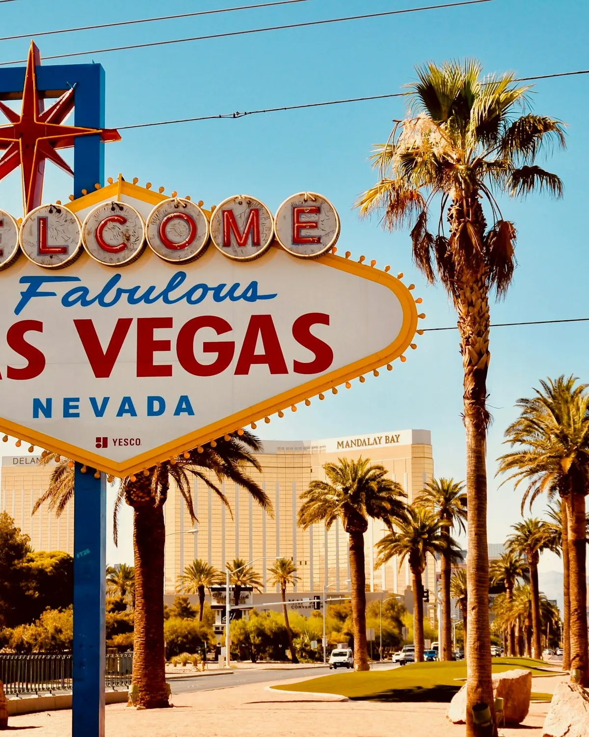 The Welcome to Fabulous Las Vegas sign under palm trees on a sunny day