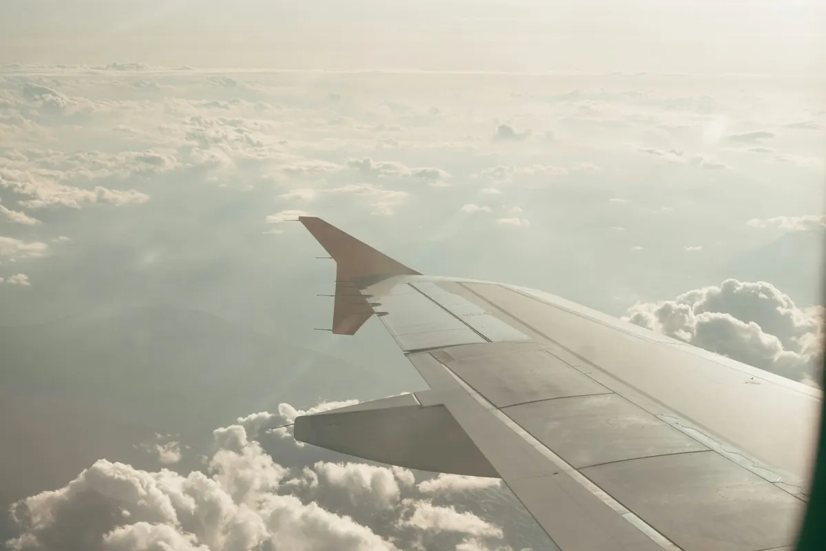 Aircraft wing above a layer of white cloud